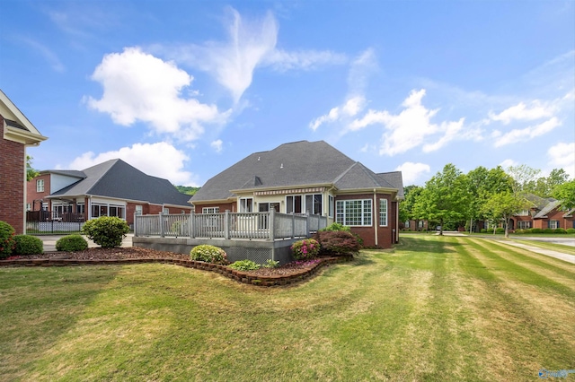 rear view of house with a yard and a deck