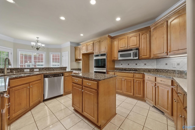 kitchen featuring crown molding, appliances with stainless steel finishes, an inviting chandelier, a sink, and light tile patterned floors
