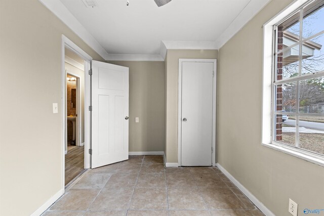 unfurnished bedroom with baseboards, crown molding, and light tile patterned floors