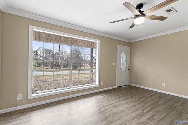 entryway with crown molding, wood finished floors, baseboards, visible vents, and ceiling fan