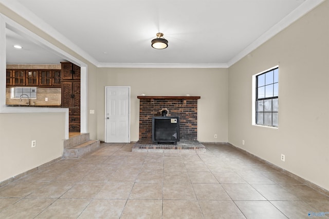unfurnished living room featuring light tile patterned flooring, a fireplace, crown molding, and a sink