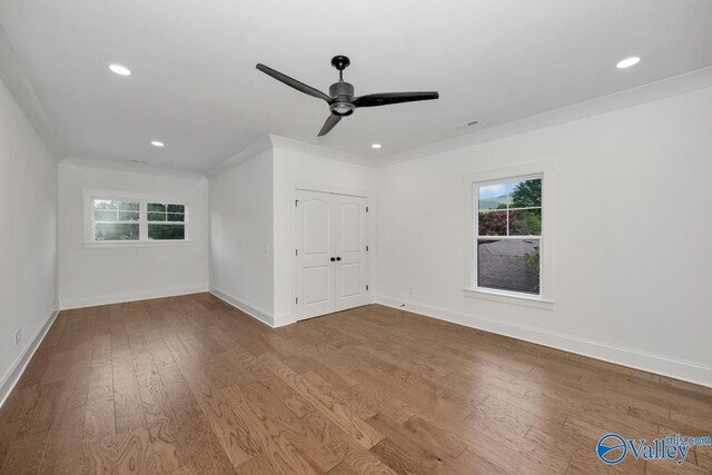 unfurnished room featuring hardwood / wood-style flooring, ornamental molding, a wealth of natural light, and ceiling fan