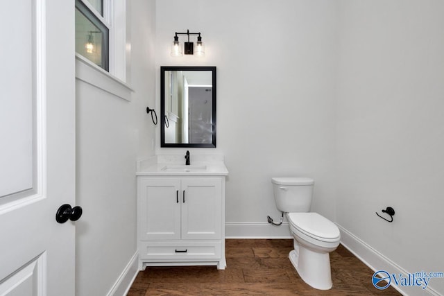 bathroom with vanity, wood-type flooring, and toilet