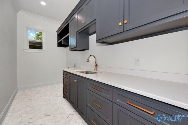 kitchen with sink, light tile patterned floors, and crown molding