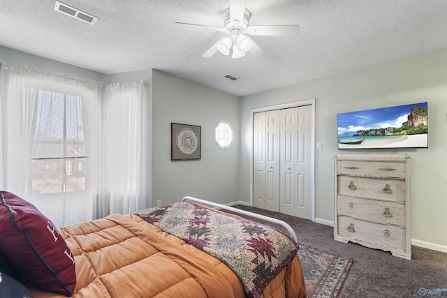 carpeted bedroom with a textured ceiling, a closet, and visible vents