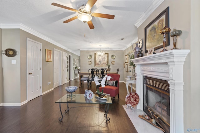 living area featuring a fireplace with flush hearth, crown molding, baseboards, wood finished floors, and ceiling fan with notable chandelier