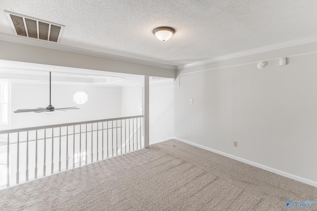 carpeted spare room with a textured ceiling, ceiling fan, and crown molding