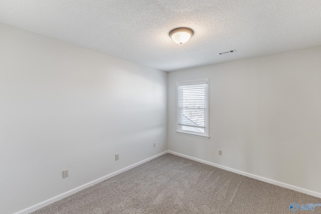 unfurnished room featuring carpet flooring and a textured ceiling