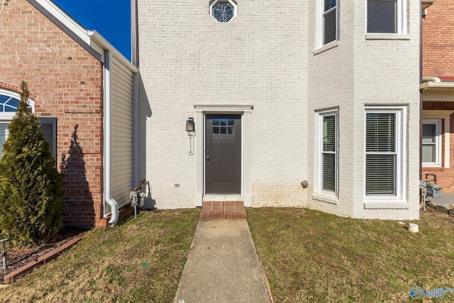 view of exterior entry featuring a yard