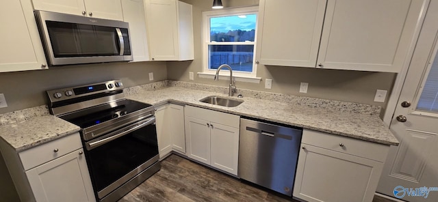 kitchen featuring sink, dark hardwood / wood-style floors, light stone countertops, white cabinetry, and stainless steel appliances