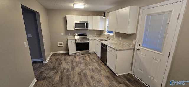 kitchen featuring dark hardwood / wood-style flooring, a textured ceiling, stainless steel appliances, sink, and white cabinets