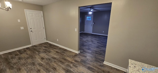 entryway featuring ceiling fan with notable chandelier, a textured ceiling, and dark hardwood / wood-style flooring