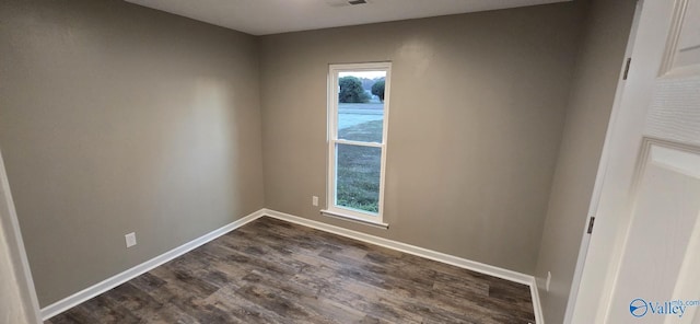 empty room with dark hardwood / wood-style flooring