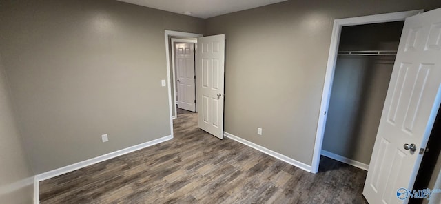 unfurnished bedroom with dark hardwood / wood-style floors and a closet