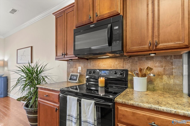 kitchen with visible vents, ornamental molding, backsplash, brown cabinets, and black appliances