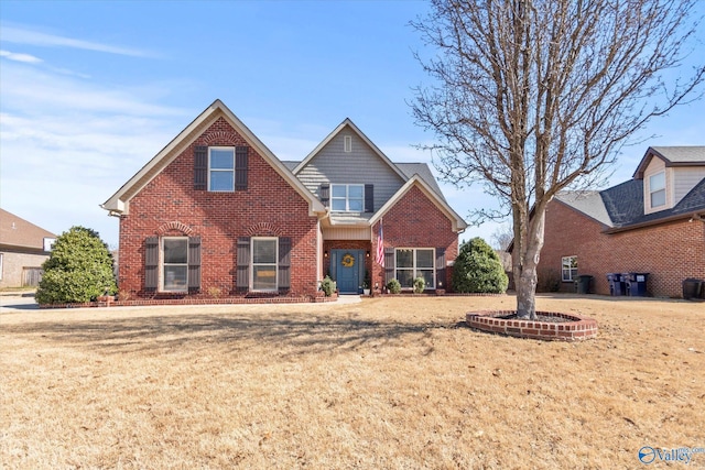 view of front of house featuring brick siding and a front yard