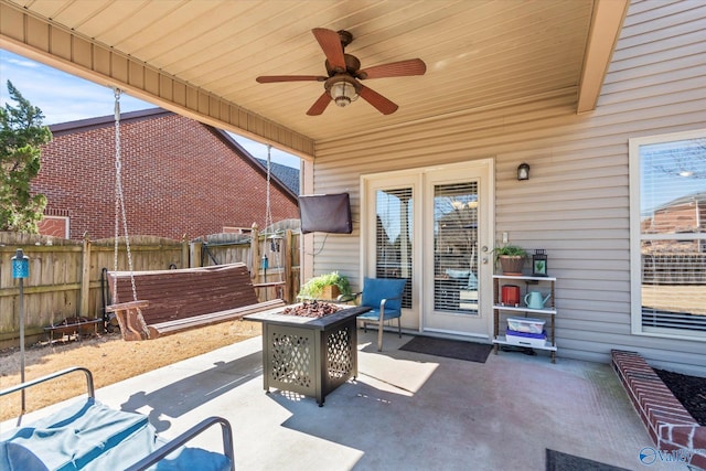 view of patio / terrace featuring an outdoor fire pit, fence, and ceiling fan