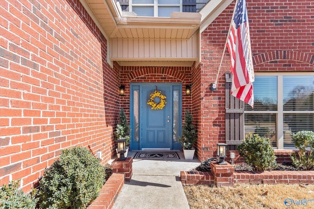 entrance to property featuring brick siding