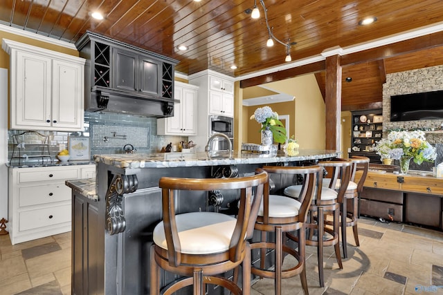 900 Menominee Rd, Langston, AL 35755 - kitchen with wooden ceiling, stone countertops, decorative backsplash, stone tile flooring, and a kitchen island with sink