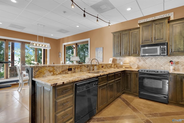 900 Menominee Rd, Langston, AL 35755 - kitchen featuring black appliances, a peninsula, light stone countertops, tasteful backsplash, and track lighting