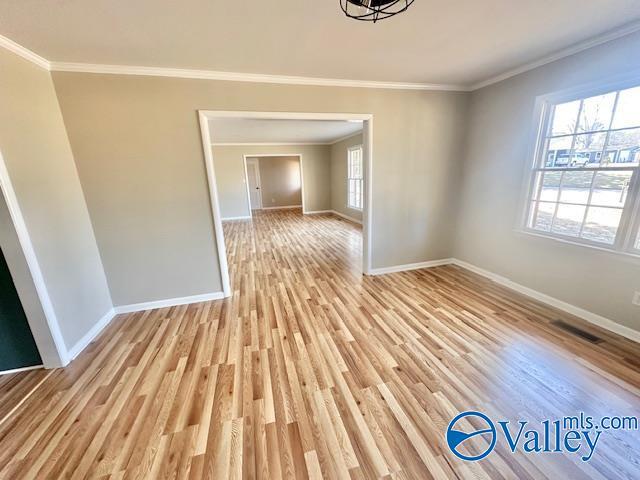 unfurnished dining area with light wood-type flooring, plenty of natural light, visible vents, and baseboards