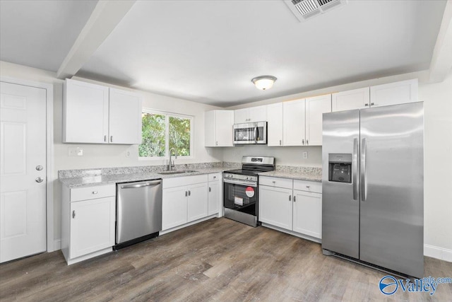 kitchen featuring sink, dark wood-type flooring, appliances with stainless steel finishes, and white cabinets