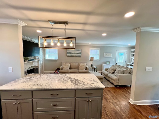 kitchen featuring pendant lighting, plenty of natural light, dark hardwood / wood-style flooring, and ornamental molding