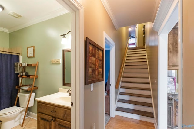 interior space featuring vanity, crown molding, toilet, and hardwood / wood-style flooring