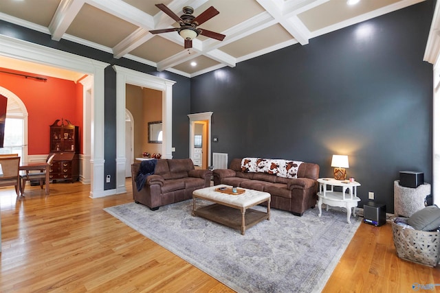 living room with ceiling fan, light wood-type flooring, crown molding, and beam ceiling