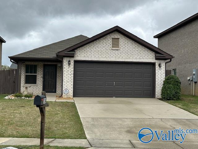 134 Winstead Cir, Owens Cross Roads, AL 35763 - single story home featuring a front yard, brick siding, concrete driveway, and an attached garage