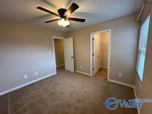 134 Winstead Cir, Owens Cross Roads, AL 35763 - unfurnished bedroom with a spacious closet, a ceiling fan, carpet, and baseboards