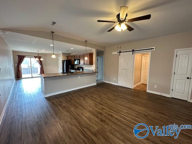 134 Winstead Cir, Owens Cross Roads, AL 35763 - kitchen with a barn door, dark wood finished floors, fridge, stainless steel microwave, and ceiling fan