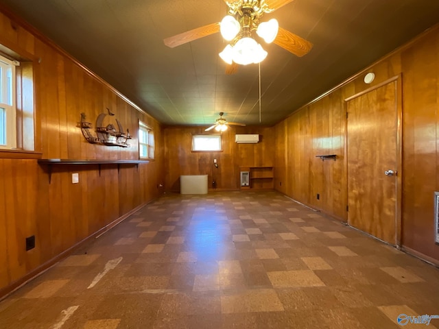 basement featuring a wall mounted air conditioner, tile patterned floors, a ceiling fan, heating unit, and wood walls