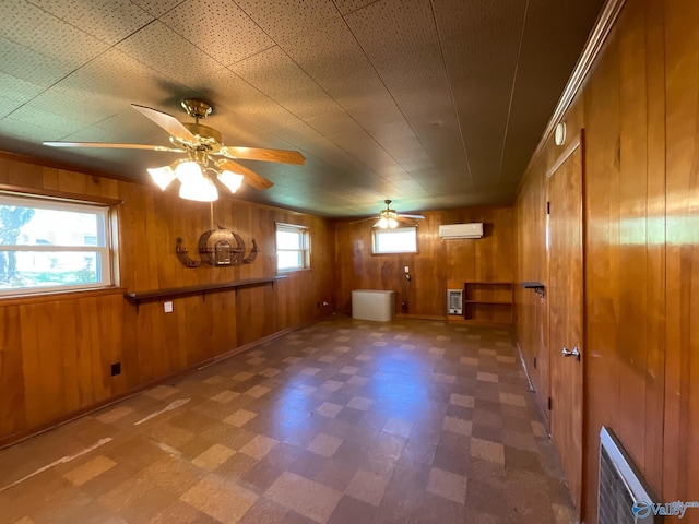 interior space featuring an AC wall unit, tile patterned floors, ceiling fan, and plenty of natural light