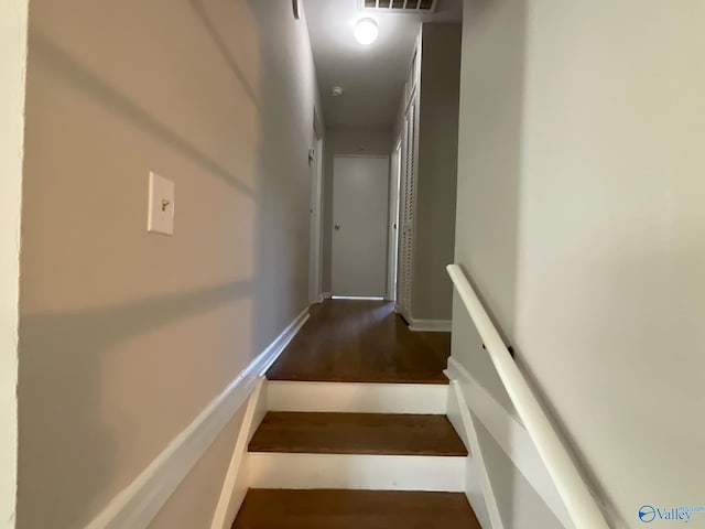 stairs with visible vents, baseboards, and wood finished floors