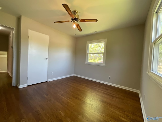 unfurnished room featuring dark wood-style floors, baseboards, and ceiling fan