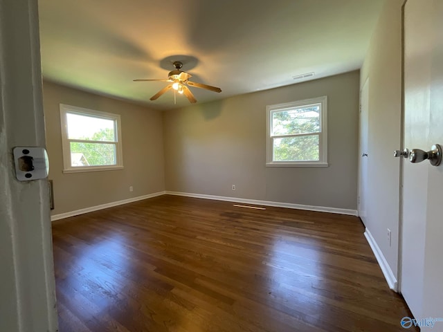 unfurnished bedroom featuring ceiling fan, visible vents, baseboards, and dark wood finished floors