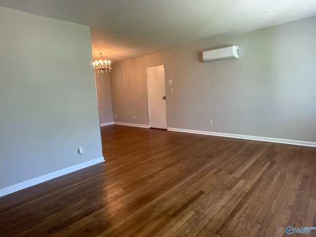 unfurnished room featuring a chandelier, dark wood-type flooring, an AC wall unit, and baseboards