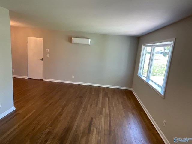 spare room featuring dark wood-style floors and baseboards