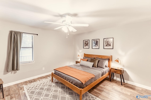 bedroom with ceiling fan, baseboards, and wood finished floors