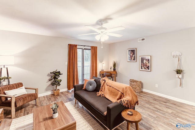 living area with light wood finished floors, baseboards, visible vents, and ceiling fan