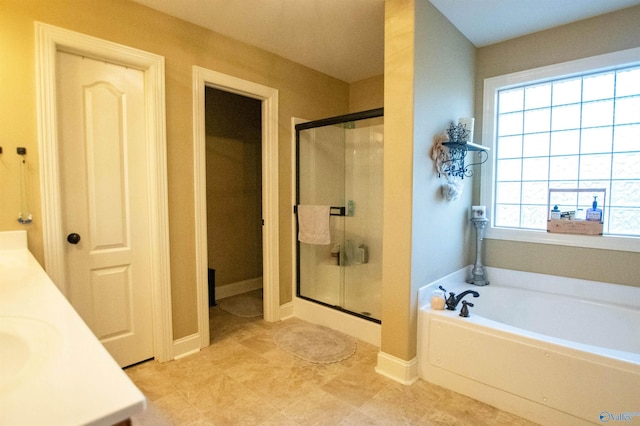 bathroom featuring plus walk in shower, vanity, and tile patterned floors