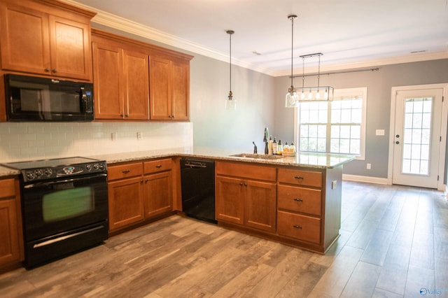 29960 Copper Run Dr, Harvest, AL 35749 - kitchen with black appliances, a peninsula, brown cabinets, light wood-style floors, and tasteful backsplash