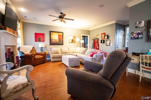 living room featuring ceiling fan, a fireplace, ornamental molding, and hardwood / wood-style flooring