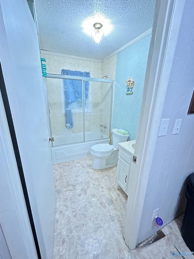 full bathroom with vanity, a textured ceiling, toilet, and combined bath / shower with glass door