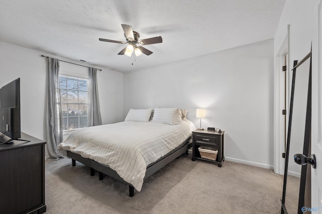 bedroom with a textured ceiling, ceiling fan, and light colored carpet