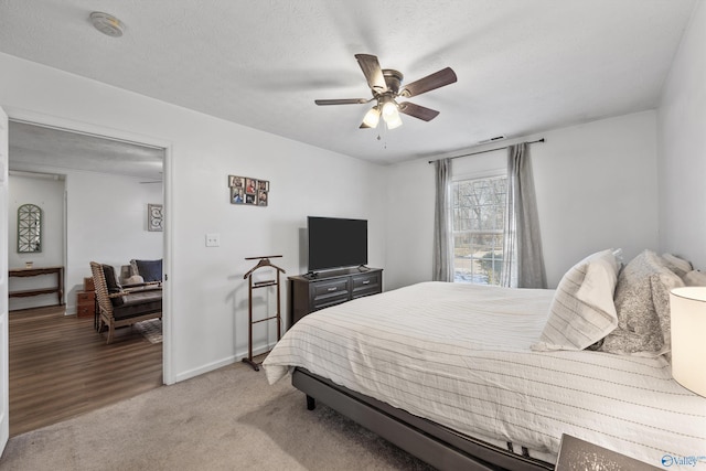 carpeted bedroom with a textured ceiling and ceiling fan