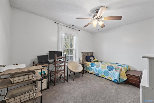 bedroom featuring ceiling fan, carpet floors, and a textured ceiling