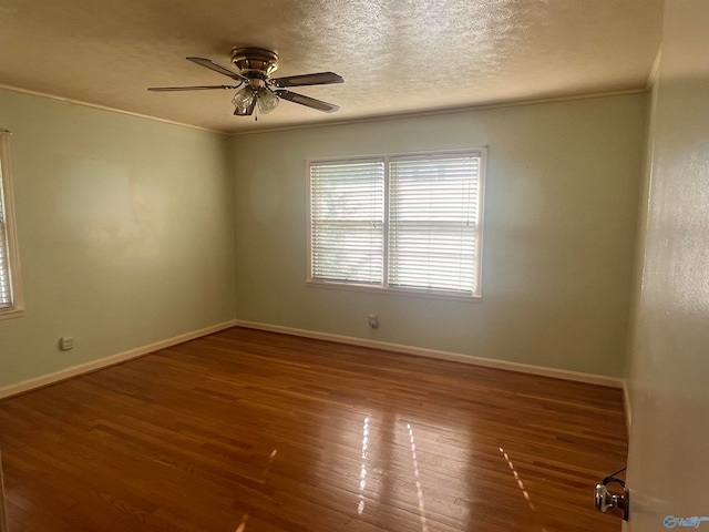 spare room featuring wood-type flooring, a textured ceiling, ornamental molding, and ceiling fan