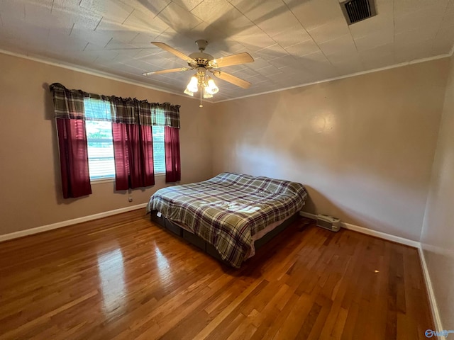 bedroom with ceiling fan, crown molding, and hardwood / wood-style flooring